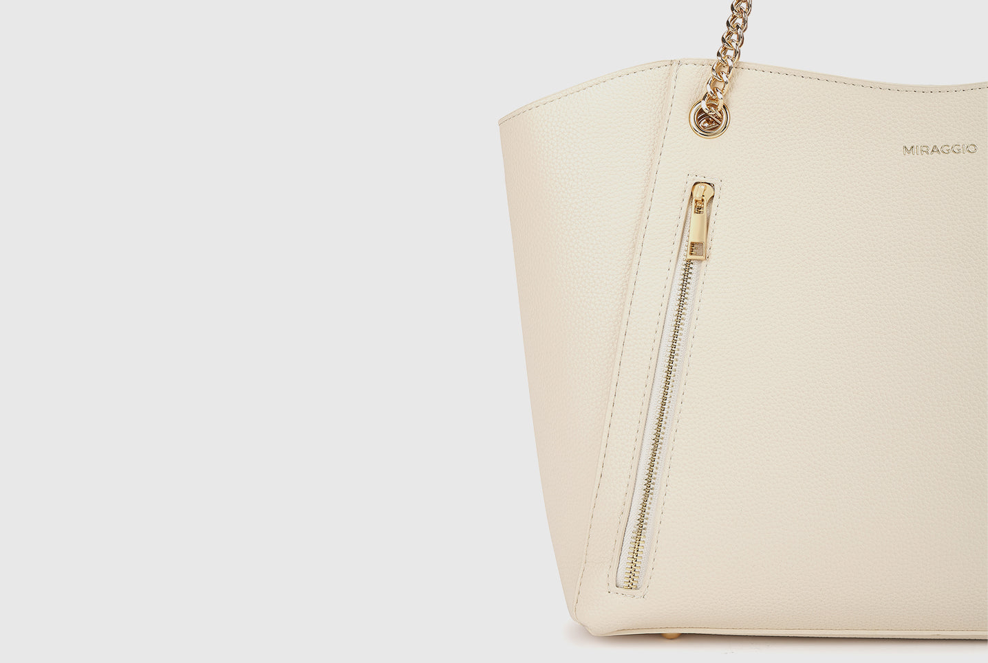 Miraggio ivory bag side view showing gold chain strap and zip pocket.