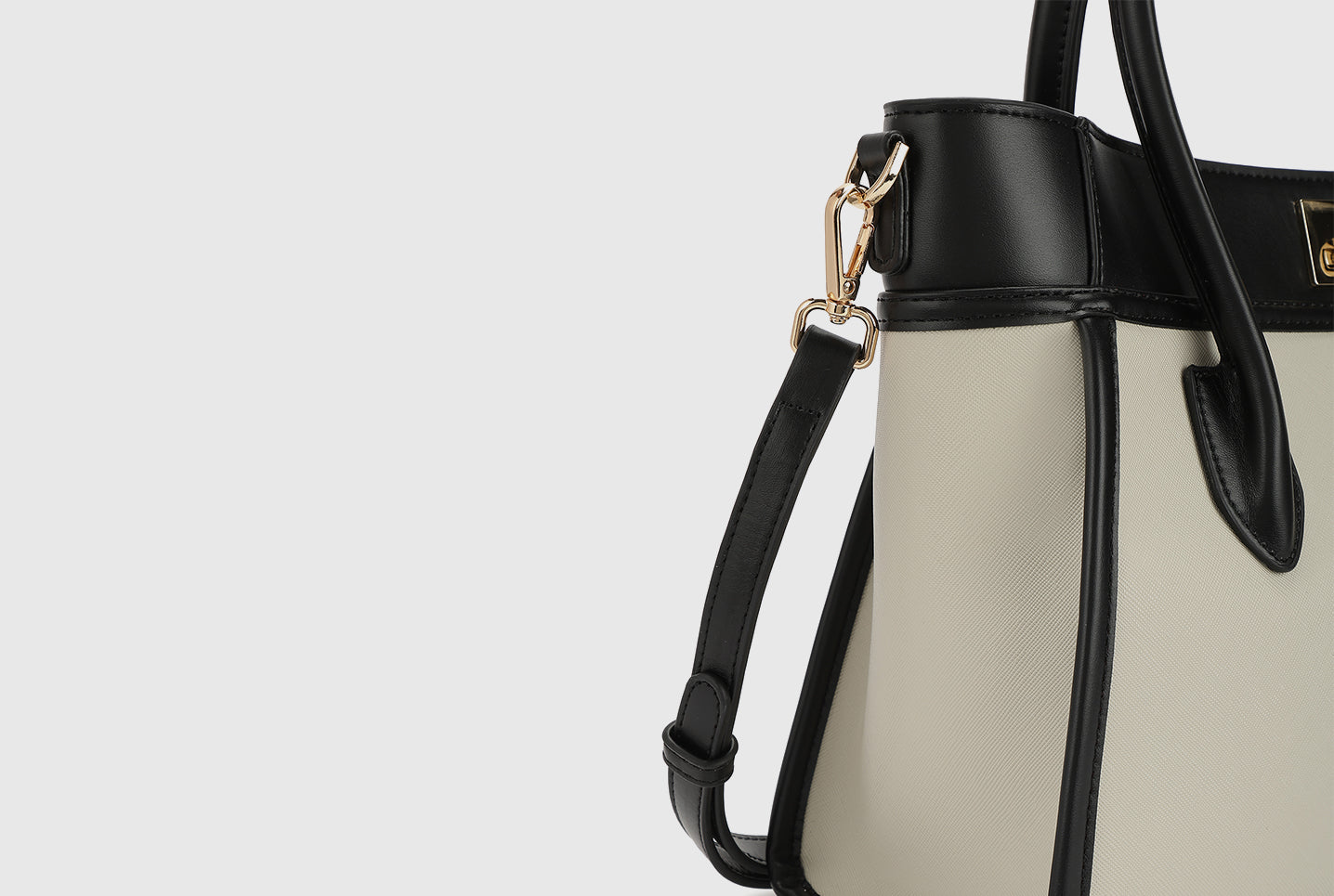 Beige Miraggio tote showing black trim and gold hardware on the shoulder strap.