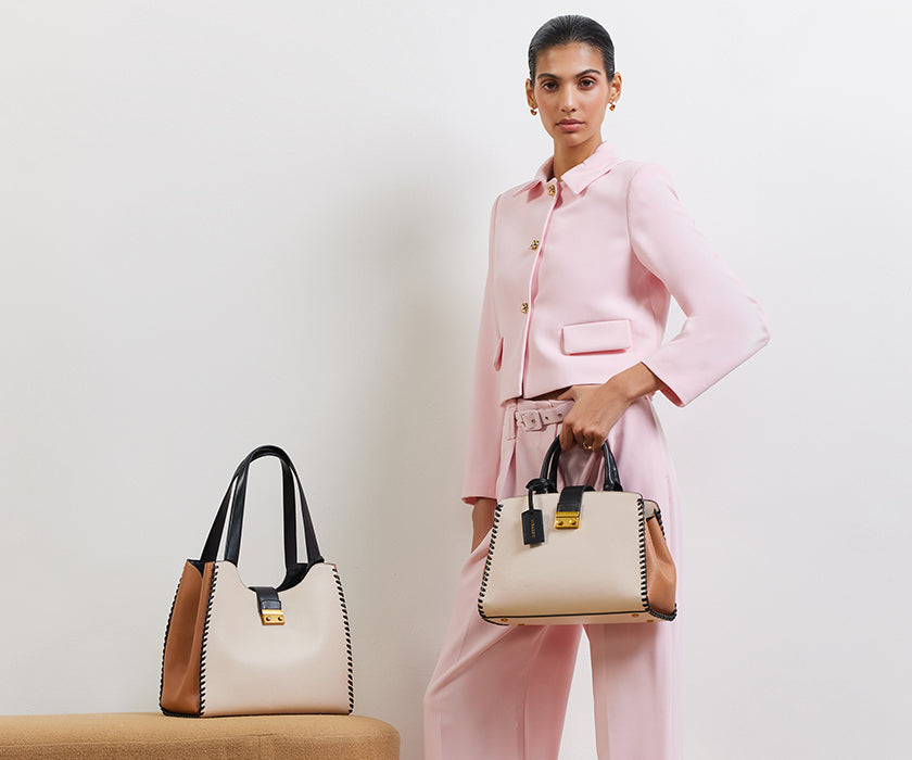 Lady carrying an ivory  handel satchel bag from Miraggio.