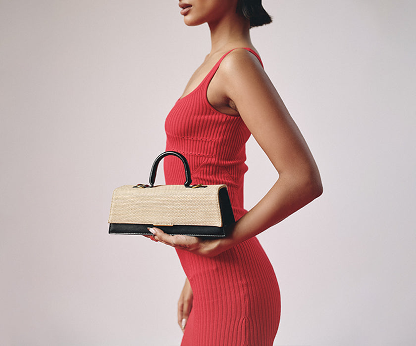 Woman carrying a beige top-handle bag  from Mirragio.